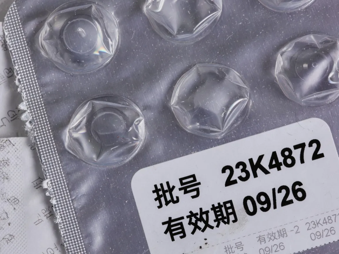 铝箔上的批号喷码特写，部分字符发糊
