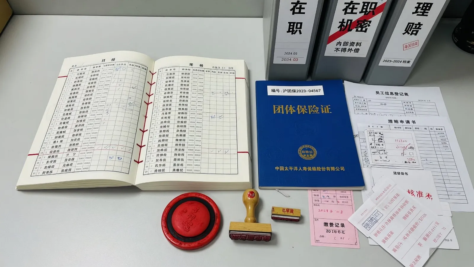 企业花名册与保险凭证骑缝装订，旁边是朱红印泥