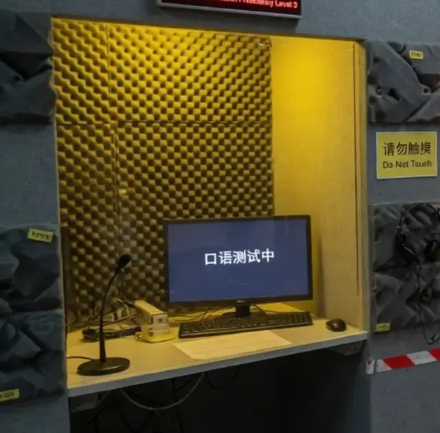 可用录音亭：暖黄吸音棉、耳机与话筒，屏上显示口语测试中