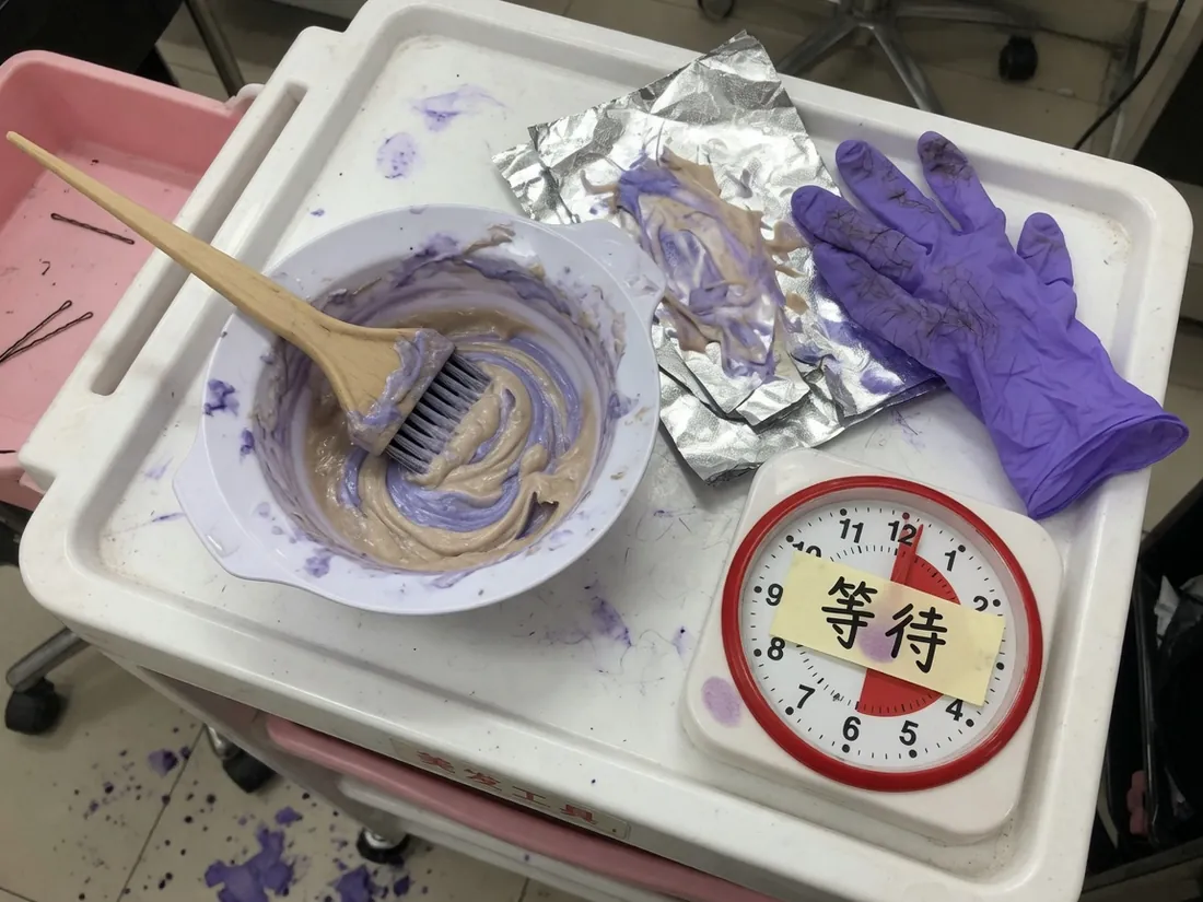 调膏碗、染刷、锡纸、紫手套，旁边一只写着等待的厨房钟