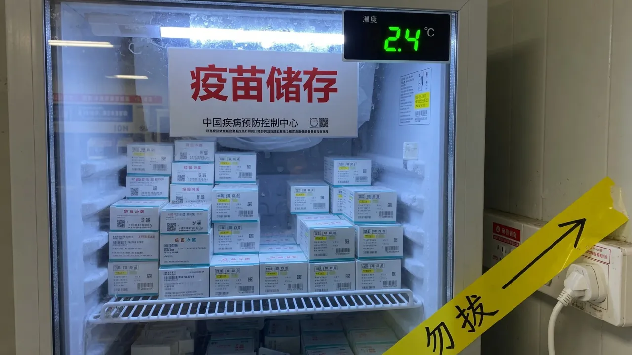 疾控苗柜玻璃门内的疫苗盒与多层货架，冷光